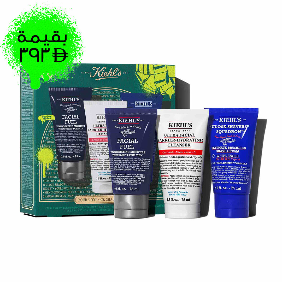A graphic featuring a dark teal Kiehl’s gift box with gold accents on the left. The box contains three products. To the right of the box, the same three products are displayed outside of the box: a dark blue tube of "KIEHL’S FACIAL FUEL MOISTURIZER," a white tube of "KIEHL’S ULTRA FACIAL BARRIER-HYDRATING CLEANSER," and a dark blue tube of "KIEHL’S CLOSE-SHAVERS SQUADRON ULTIMATE BRUSHLESS SHAVE CREAM." The box is decorated with bright green graphic paint splatters and a bow design, and features the text "YOUR 5 O’CLOCK SHADOW SHAPERS" at the bottom.