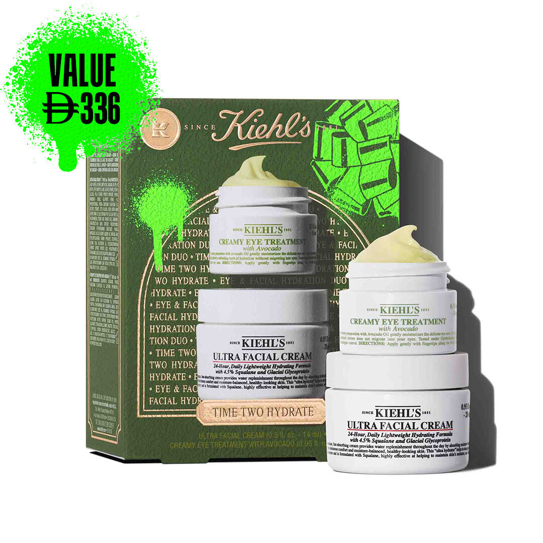 A Kiehl's green gift box is shown on the left, with "TIME TWO HYDRATE" text, and green graphic elements. To the right, two jars of products are stacked: the top jar is "KIEHL'S CREAMY EYE TREATMENT with avocado" and has a visible yellow-green swirl of product on top. The bottom jar is "KIEHL'S ULTRA FACIAL CREAM".